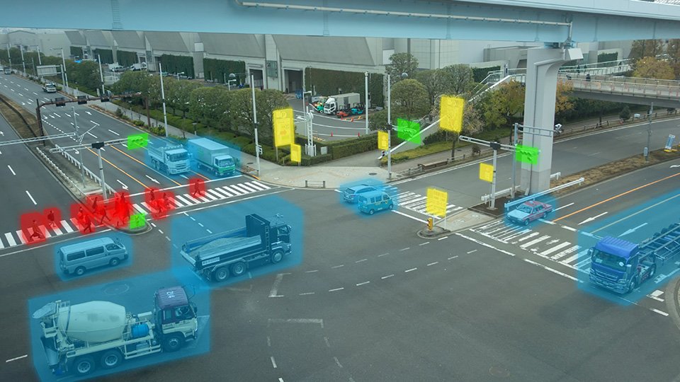 A imagem mostra um cruzamento com os veículos de diferentes categorias, marcados por inteligência artificial para contagem e categorização