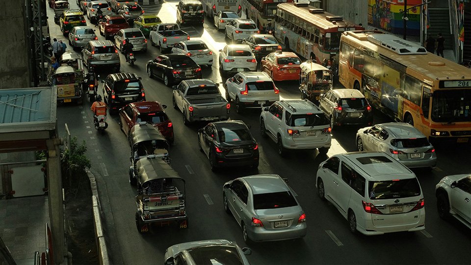 Imagem de tráfego de veículos intenso numa via urbana.