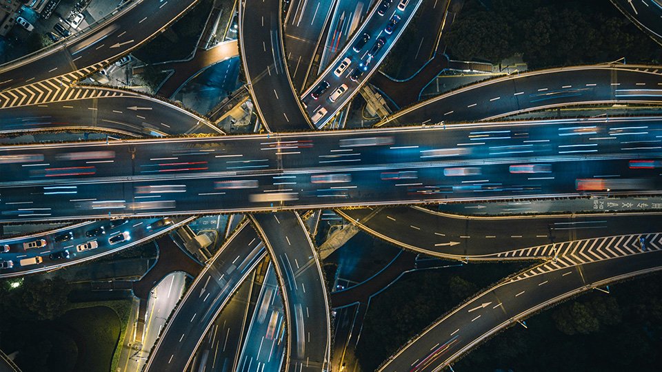 A imagem mostra múltiplas vias, com imagens borradas que denotam veículos correndo e se locomovendo