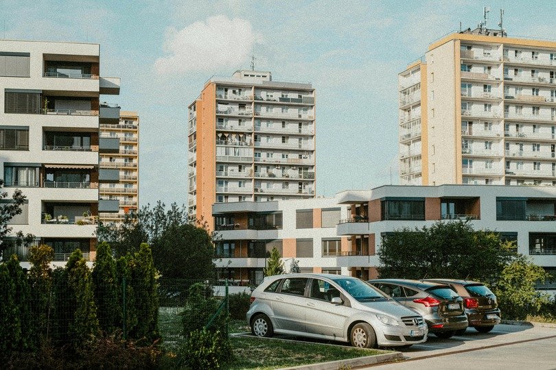 A imagem mostra ccarros estacionados em vagas de edifícios corporativos, residenciais